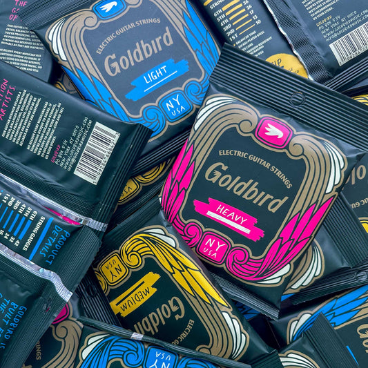 Goldbird electric guitar strings packaging in various gauges, bundle shot.