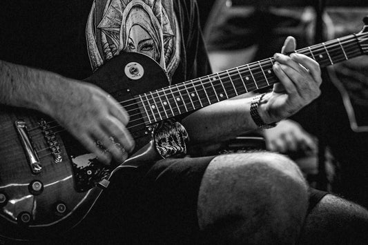 Black and white photograph of a man playing an electric guitar