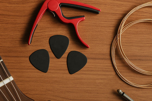 A capo, picks, guitar strings on a wooden background