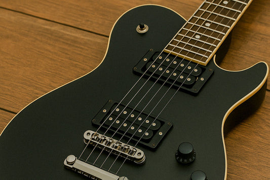 Black guitar on a wooden surface