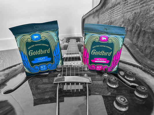 Light and Heavy Goldbird string packs on top of a guitar body