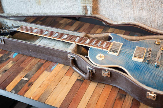 A blue guitar laying in a case