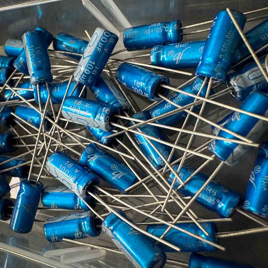 Close-up of blue capacitors with metal leads on a clear background
