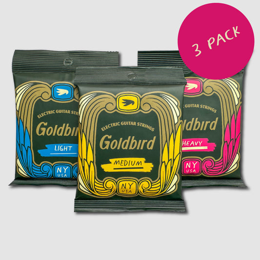 Three packs of Goldbird electric guitar strings with different weights on a light gray background.