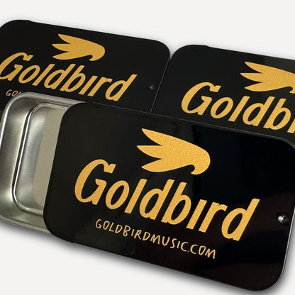 Black and gold Goldbird pick tins on a white background
