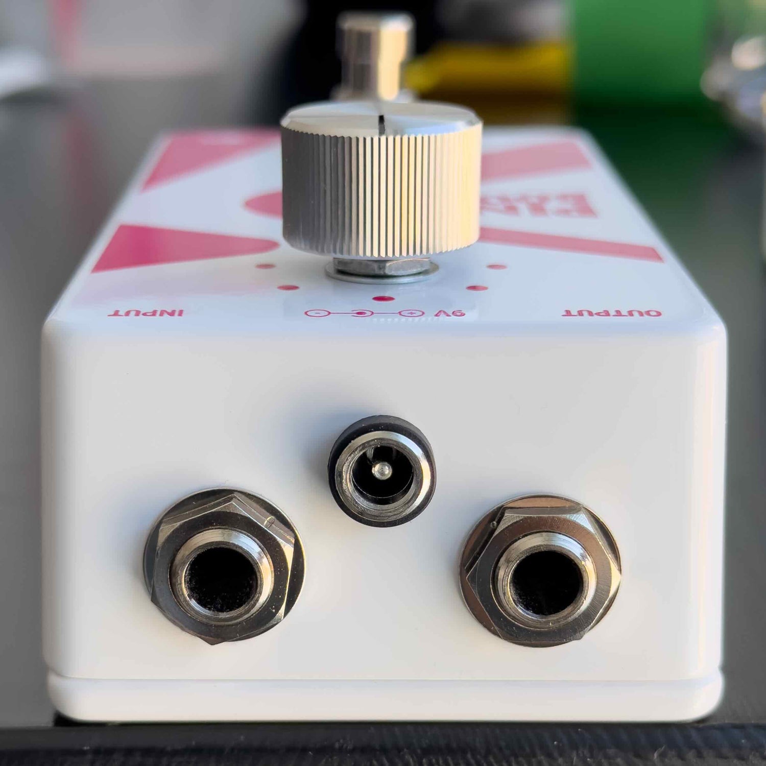 Pink Boost guitar pedal with three jacks and a knob on top